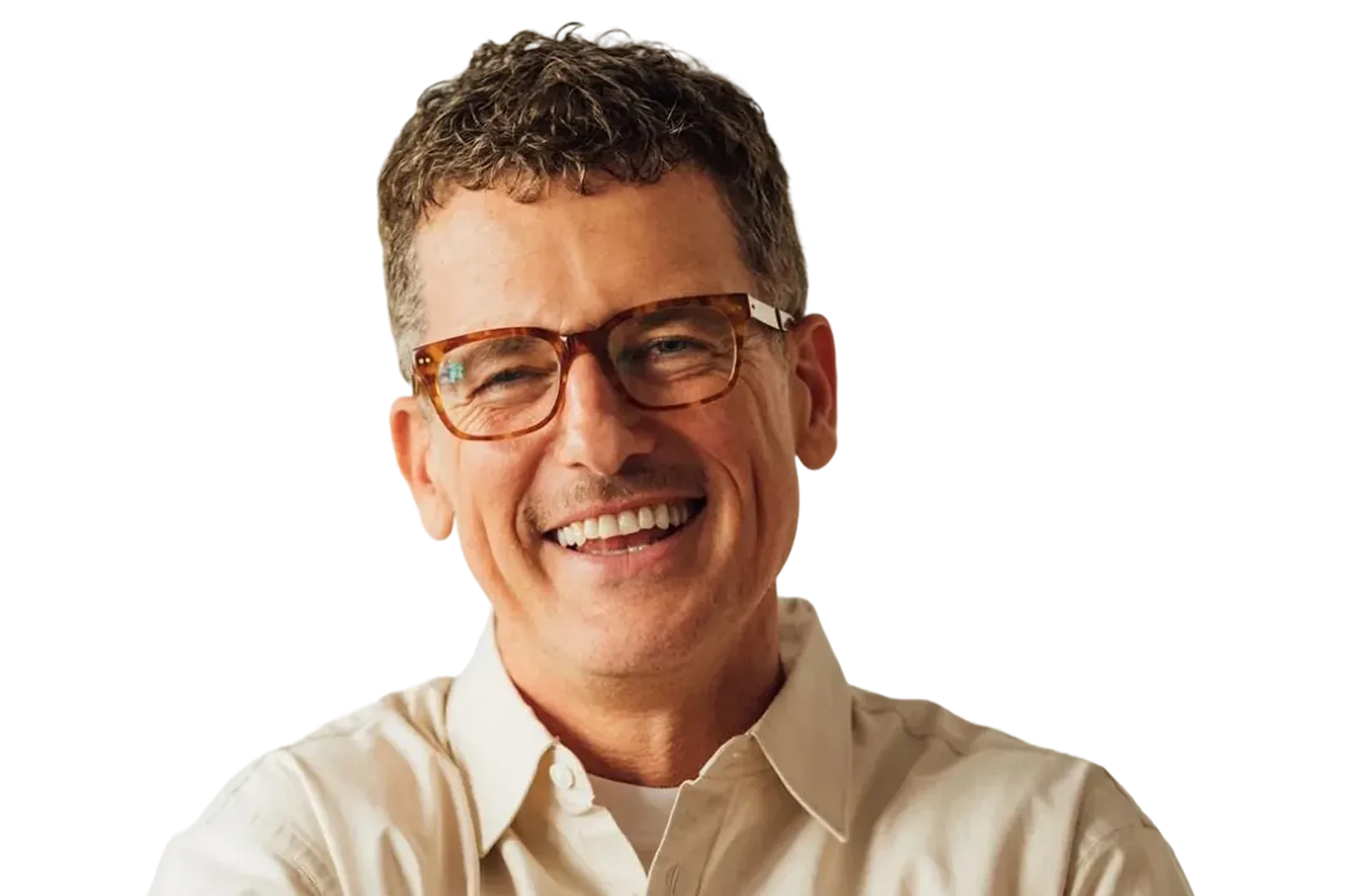 Smiling middle-aged man with short curly hair wearing tortoiseshell glasses and a beige button-up shirt.